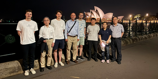 Personengruppe stehend mit der Sydney Opera im Hintergrund